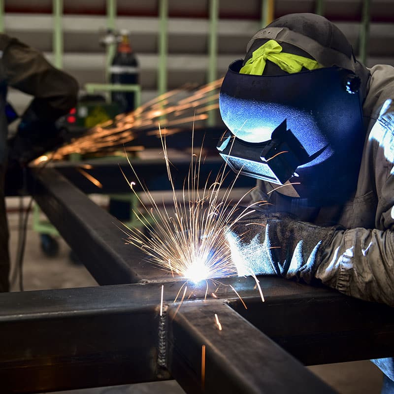 Welder welding a cross section of metal tubes
