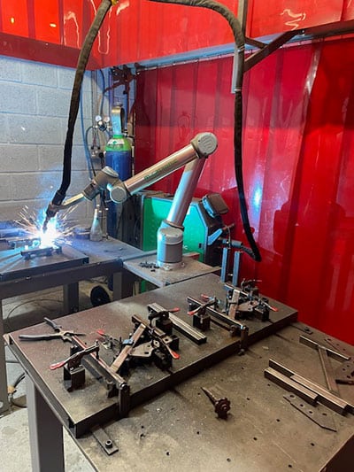 CoWelder welding metal parts held in a fixture