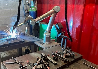 CoWelder welding metal parts held in a fixture