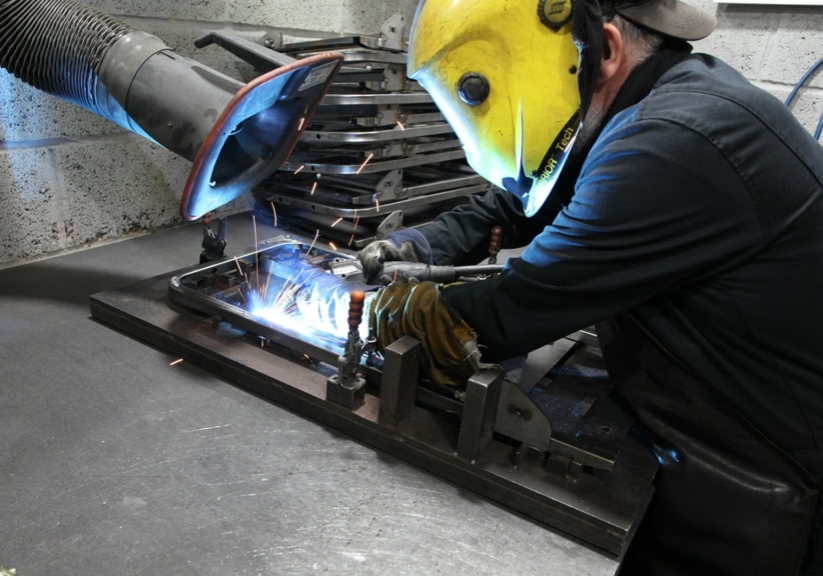 Man welding a metal tube.