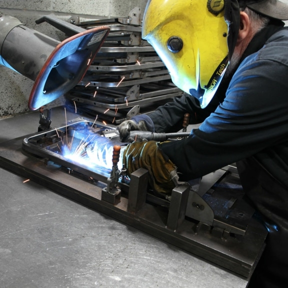 Man welding a metal tube.
