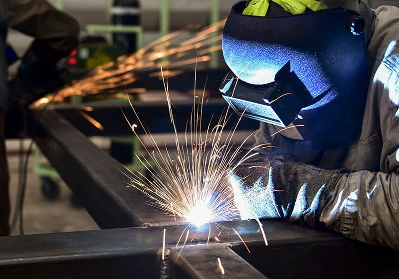 Welder welding a cross section of metal tubes